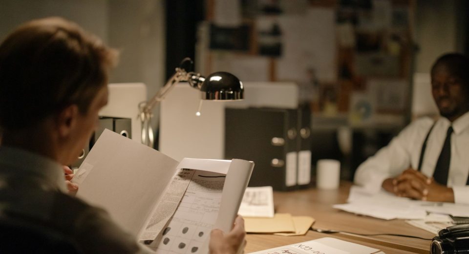 Investigadores analisam documentos em um escritório durante uma apuração policial.