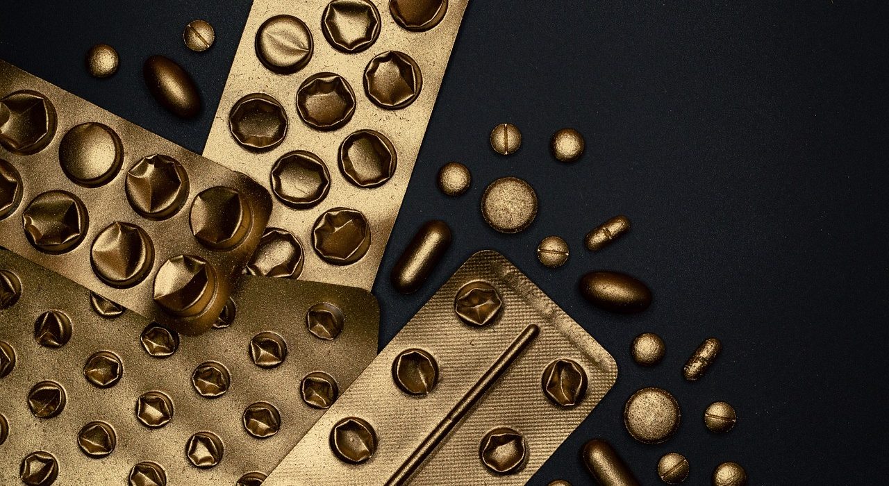Medicamentos e comprimidos organizados em embalagens sobre uma superfície.