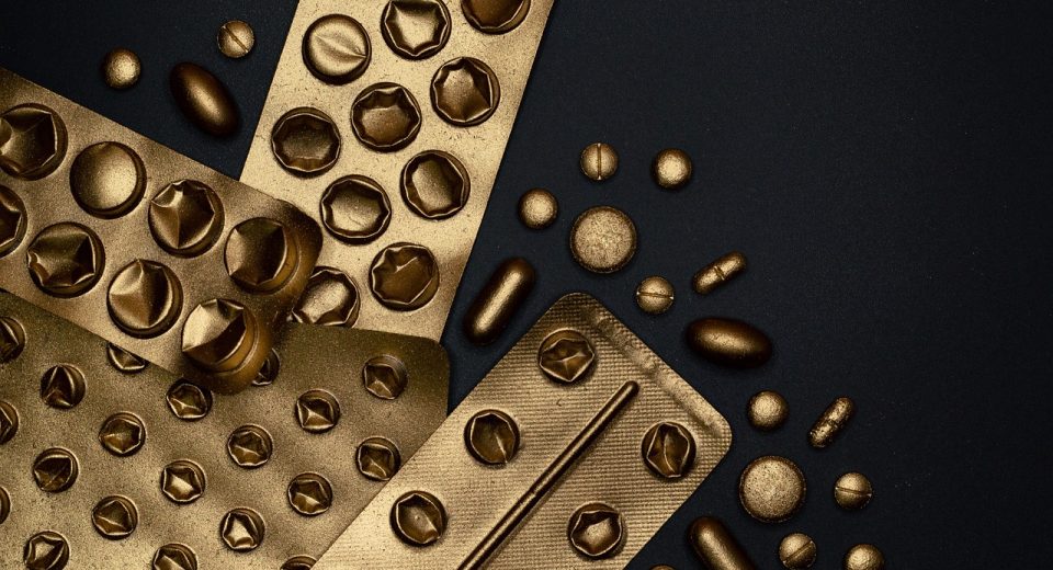 Medicamentos e comprimidos organizados em embalagens sobre uma superfície.